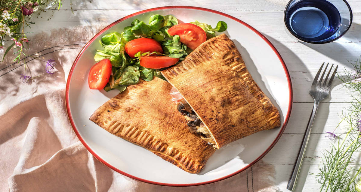 Pizza calzone au jambon cru et fior di latte avec une base sauce tomate et du comté râpé