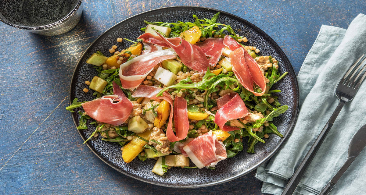 Salade de jambon serrano, mozzarella et pêches rôties préparée avec du fenouil et du couscous perlé