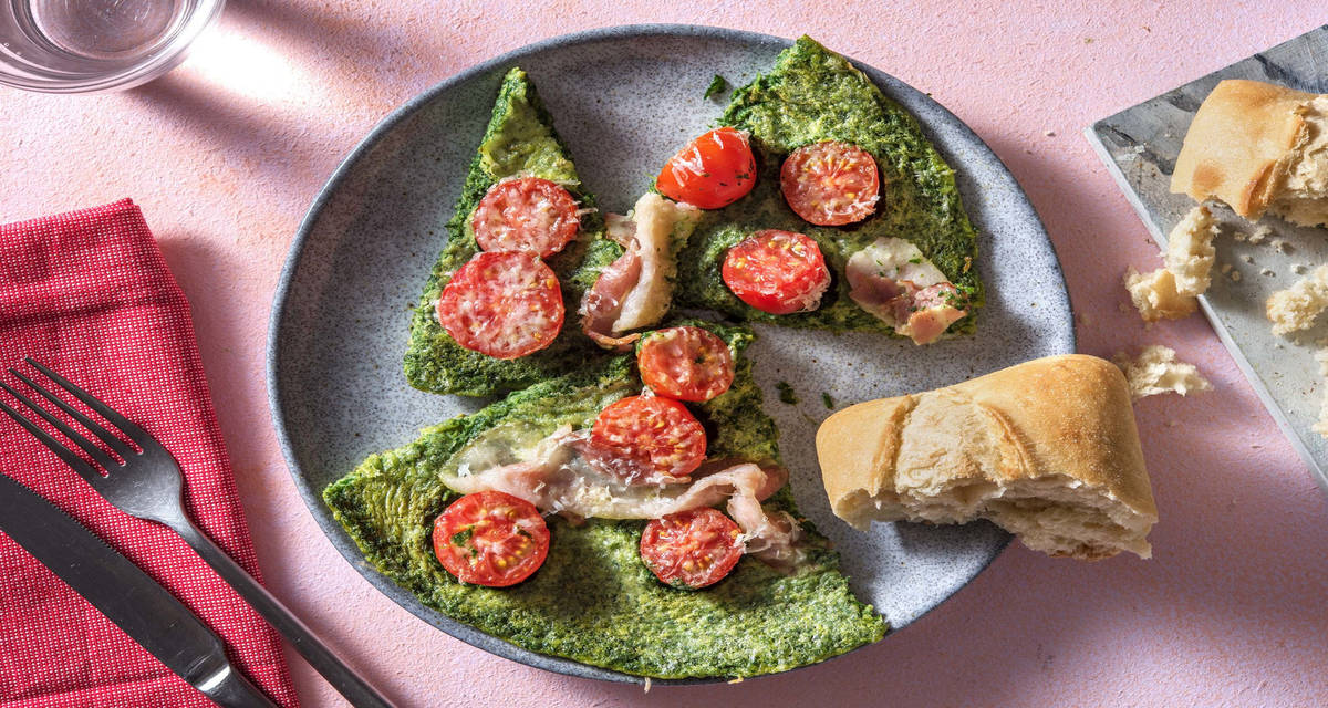 Omelette verte au jambon fumé & comté râpé garnie de tomates cerises, d'épinards avec un petit pain ciabatta