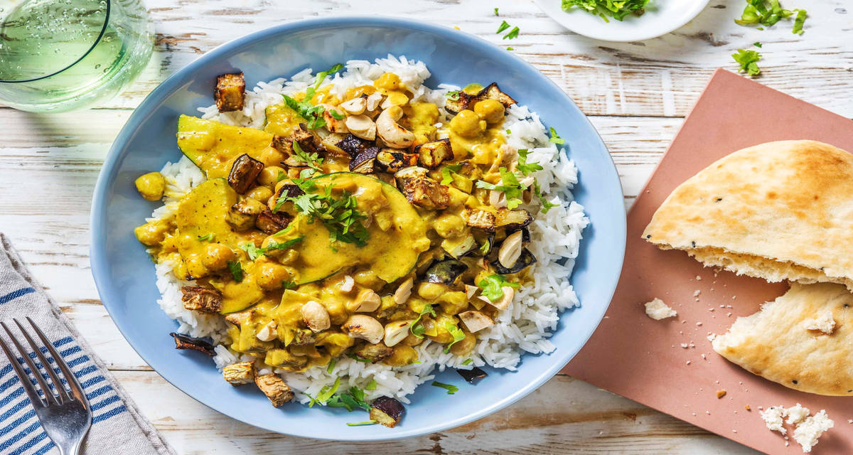 Curry d'aubergine rôtie & pois chiches servi avec de la coriandre, du citron vert et des noix de cajou