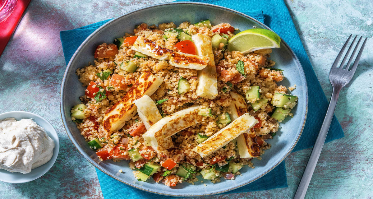 Salade de couscous au concombre & frites de halloumi avec de la tomate, du citron vert et une sauce yaourt-tahini