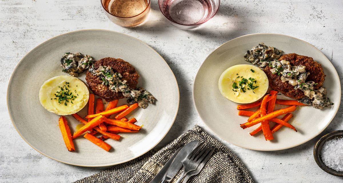 Hamburguesa de ternera con salsa de setas acompañada de zanahorias asadas y puré de patata