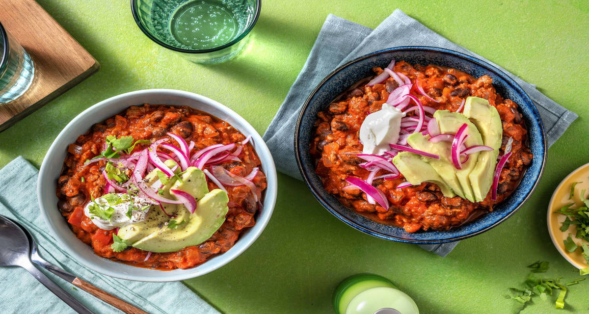 Chili con carne au bœuf et aux haricots noirs avec du fromage blanc & des pickles d'oignon rouge