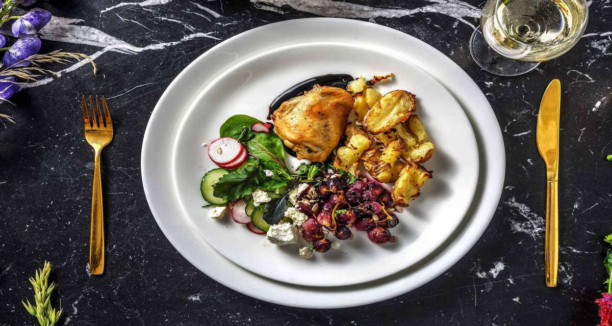 Cuisse de poulet confite et salade d'automne avec des raisins rôtis et un sirop de balsamique