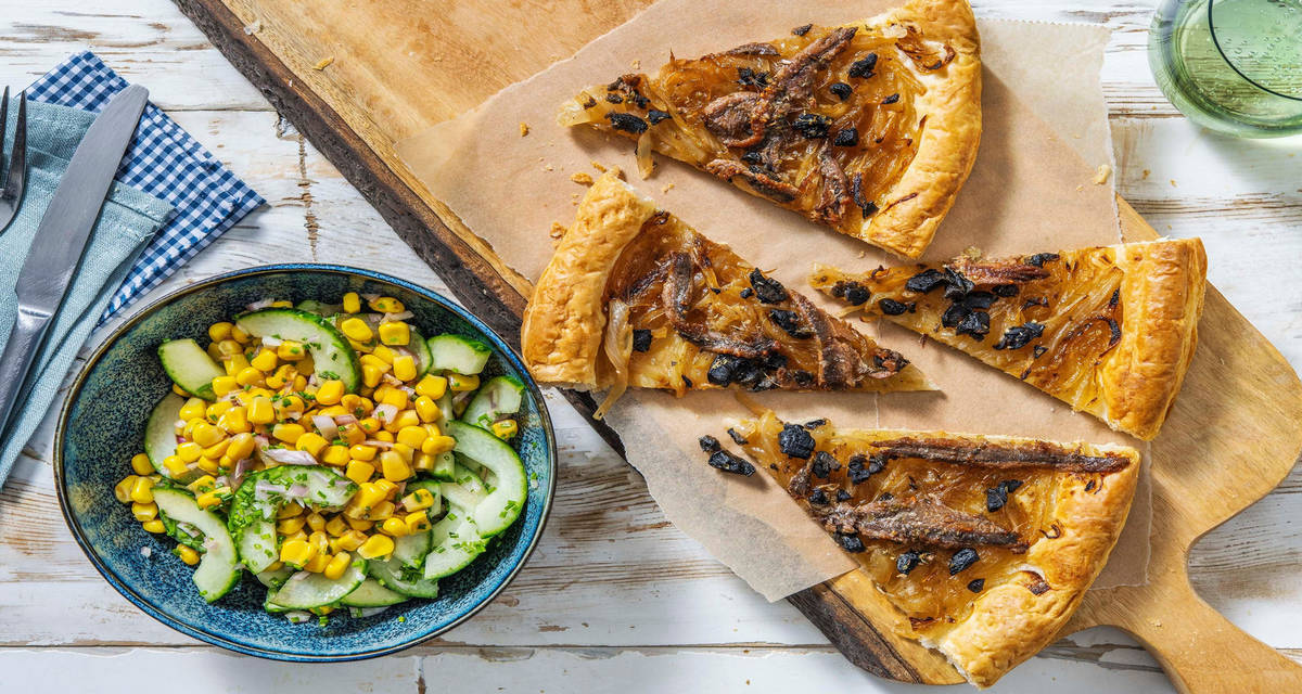 Tarte pissaladière feuilletée avec une salade de concombre, maïs et ciboulette