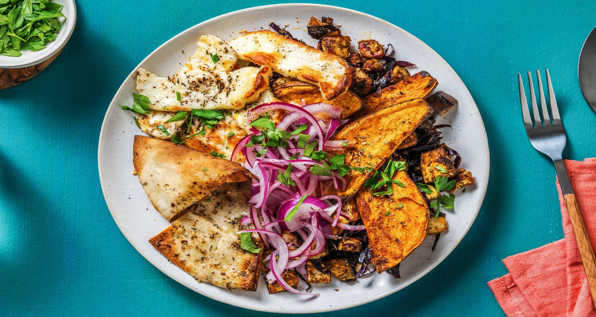 Salade orientale de patates douce, halloumi & chou rouge avec du zaatar, de l'aubergine et des pains pitas