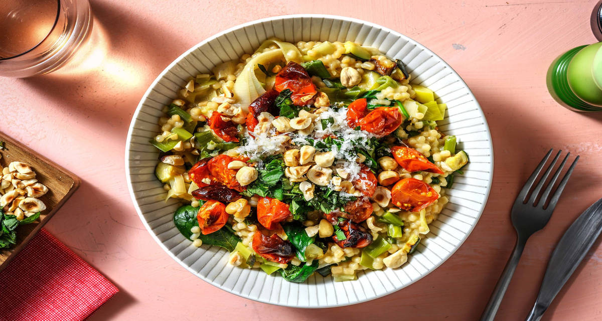 Krämig pärlcouscous med körsbärstomater, spenat och hasselnötter