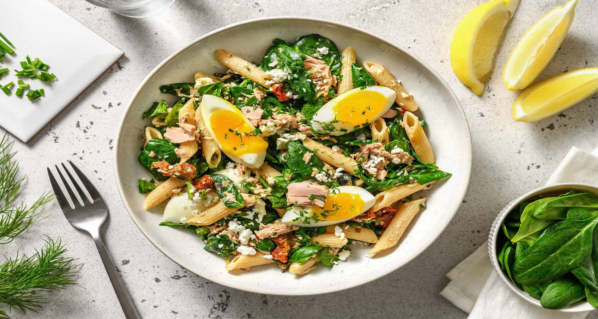 Salade de pâtes à la grecque au thon avec des câpres, des tomates séchées et des épinards