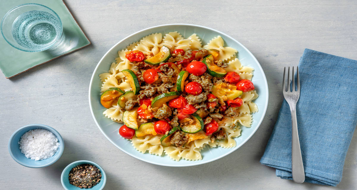 Farfalle con carne picada de ternera y salsa cremosa con calabacín y tomates cherry