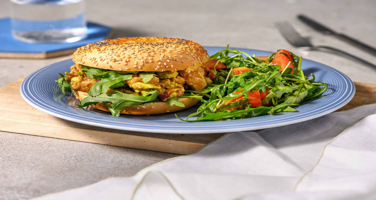 Bagel avocat, poulet & roquette avec de la tomate et des épices mexicaines
