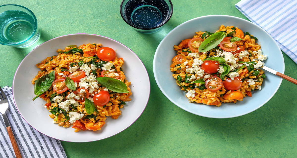 Risotto de couscous perlé, tomates & feta avec des épinards et du basilic