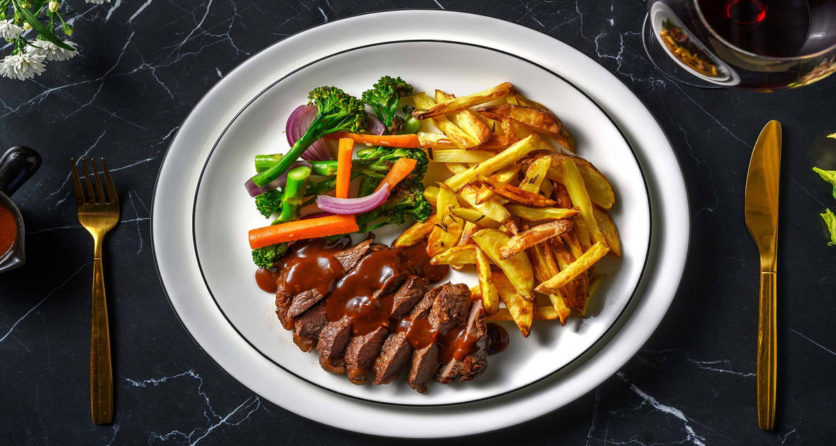 Mör ryggbiff och krämig pepparsås med pannstekta grönsaker och spröda rosmarinspommes