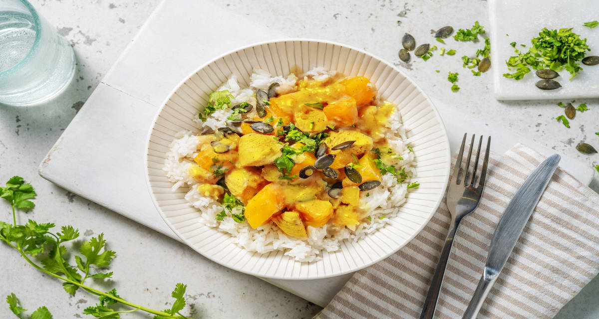 Poulet doré au curry, mangue & coco avec de la coriandre & des graines de courge