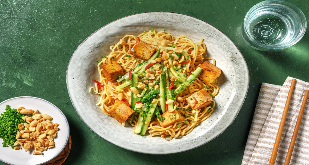 Noodles saltati, gamberi e tofu agro-piccante con arachidi e zucchine allo zenzero