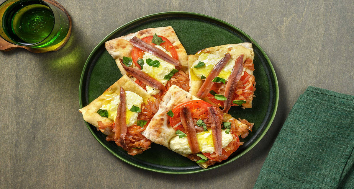 Pinsa saporita alici e mozzarella con cipolla caramellata e pomodoro fresco