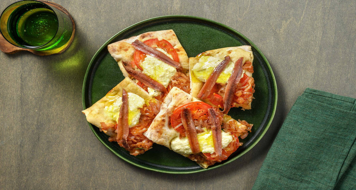Pinsa pissaladière alle alici e ricotta con cipolle caramellate e pomodoro