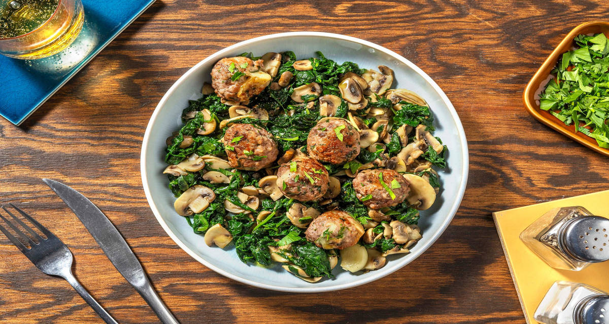 Polpette di carne ripiene di fontal filante con funghi e spinaci saltati