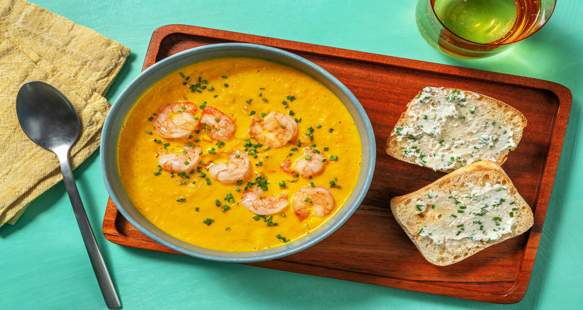 Crema casera de zanahoria y langostinos acompañada de pan con queso crema al cebollino