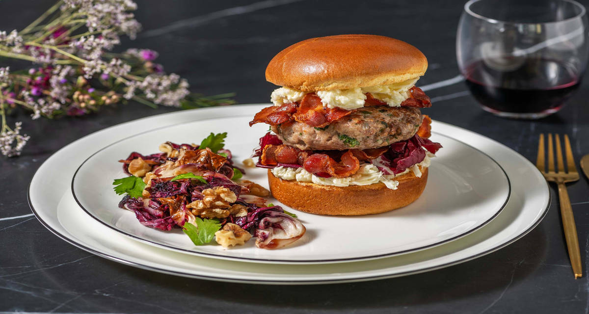 Hamburger ricco di carne, bacon e burrata con olio all'aroma di tartufo, noci e indivia