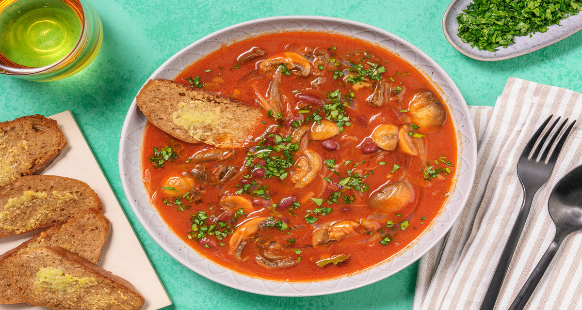 Stufato di fagioli rossi e funghi al pomodoro con pane aromatizzato all'aglio e prezzemolo