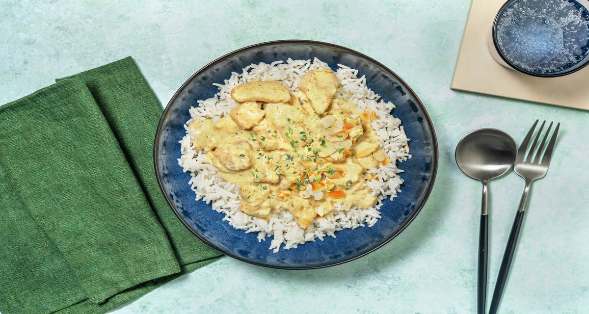 Dados de pollo en salsa de almendras acompañados de arroz