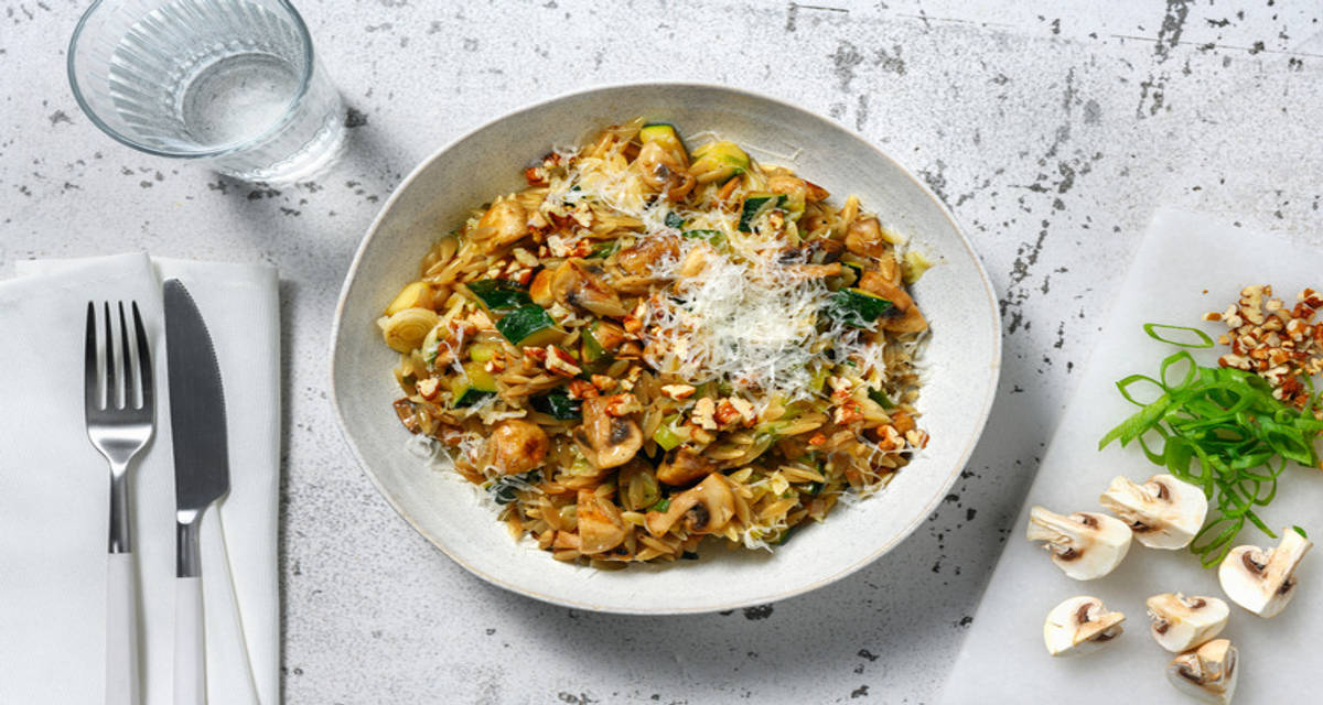 Orzotto met champignon en courgette met truffelolie, geroosterde walnoten en Italiaanse stijl kaas