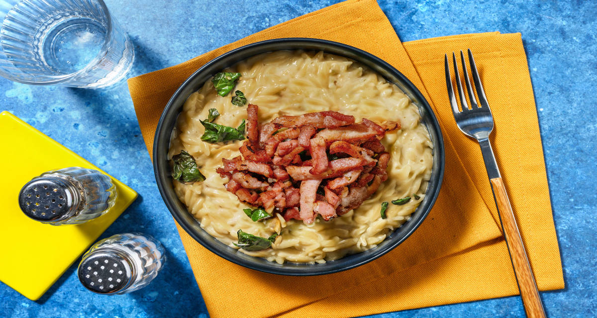 Orzo en salsa de queso con bacon crujiente con espinacas salteadas