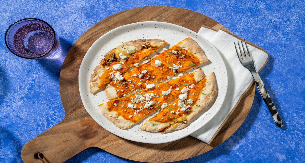 Coca con crema de pimientos y queso griego con vinagreta de miel y ajo asado