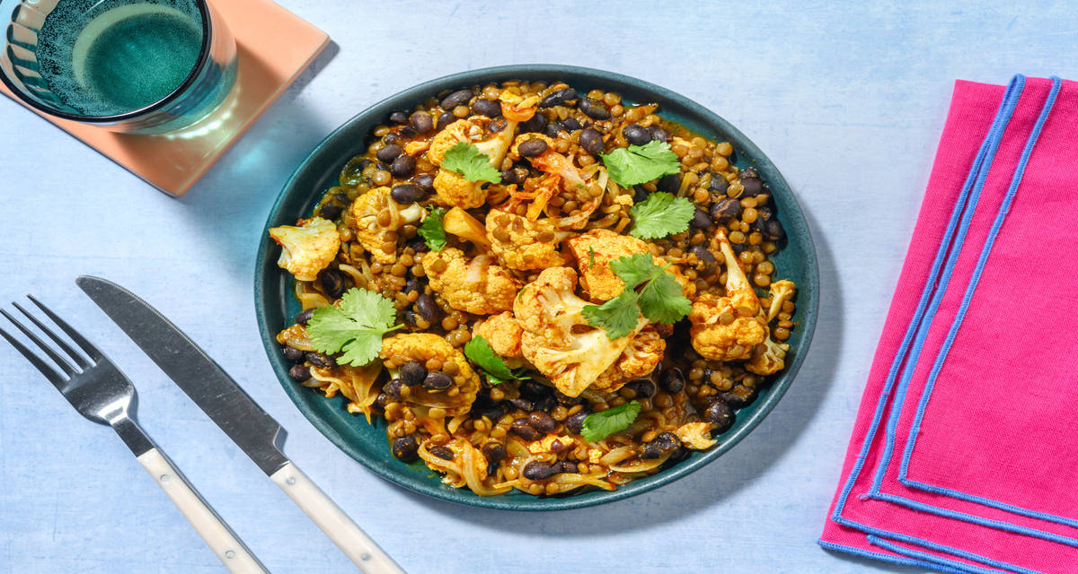 Curry cremoso de coliflor asada con alubias negras, lentejas y cilantro fresco
