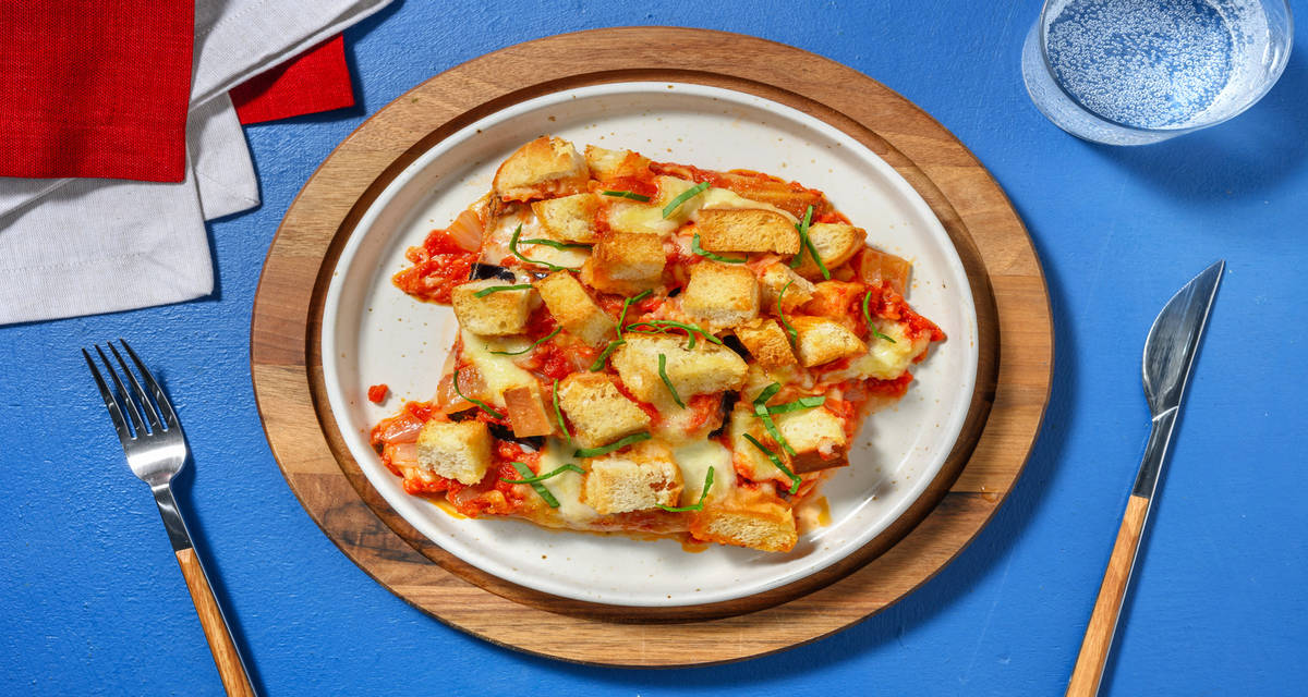 La parmigiana: berenjena con mozzarella italiana con salsa de tomate y picatostes caseros