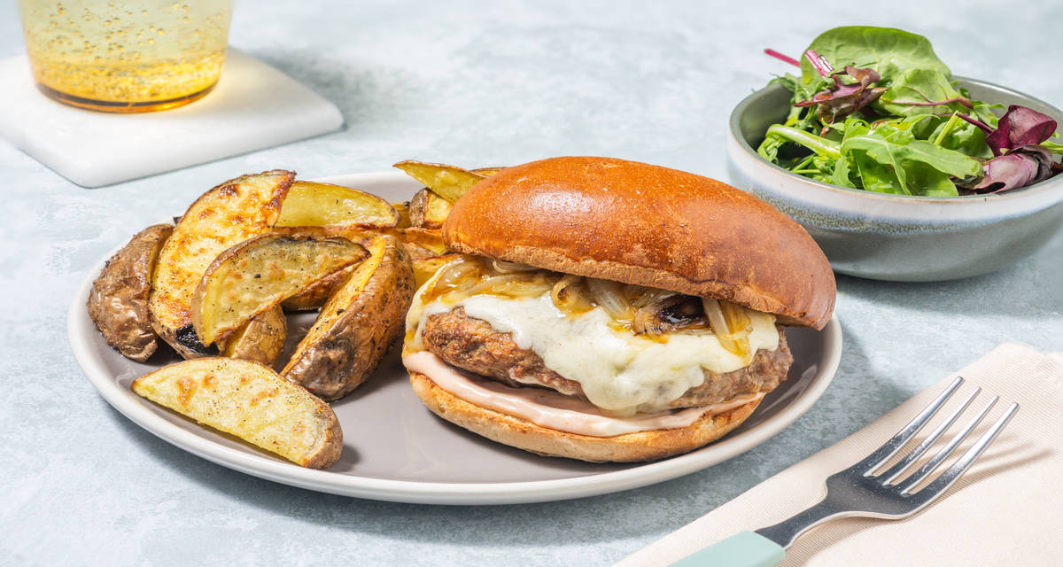 Burger di pollo al cheddar filante con cipolle caramellate e patate al forno