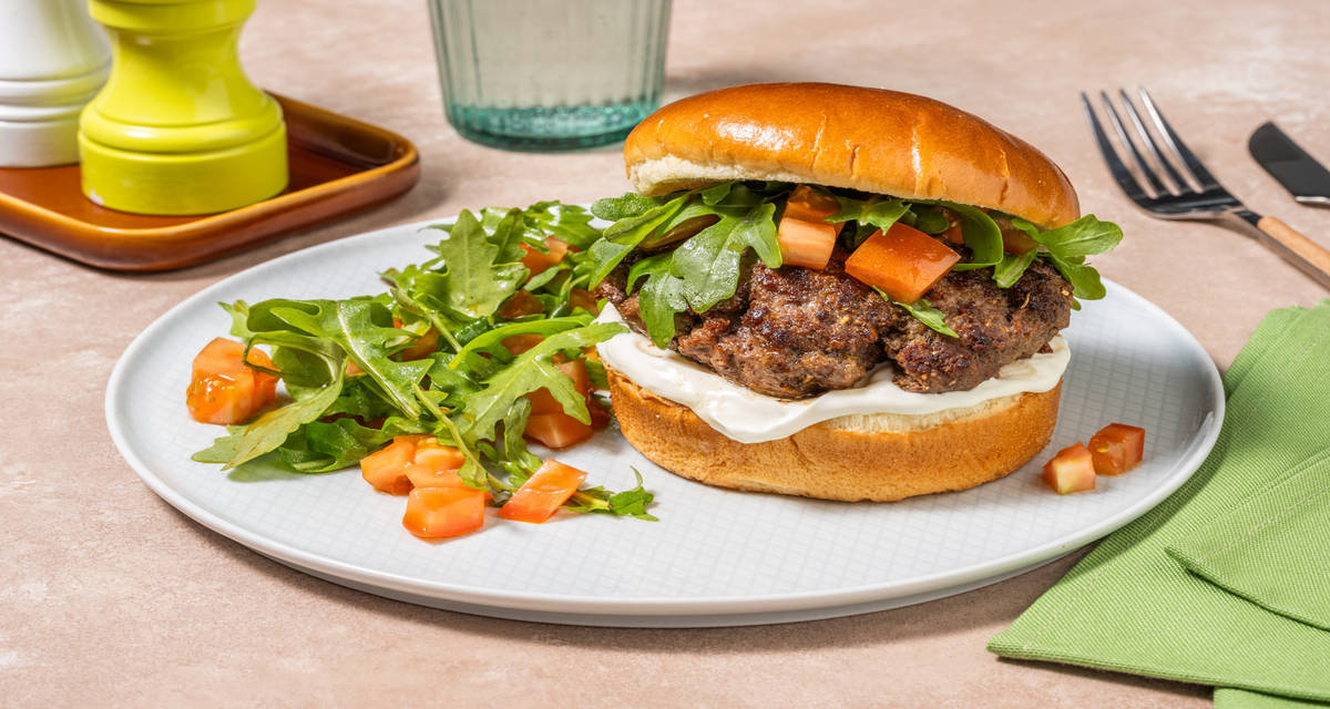 Hamburguesa casera de ternera con mayonesa acompañada de ensalada de rúcula y tomate