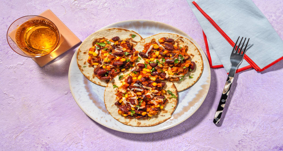 Mini tostadas ai fagioli rossi e mais con pomodoro, formaggio filante e coriandolo