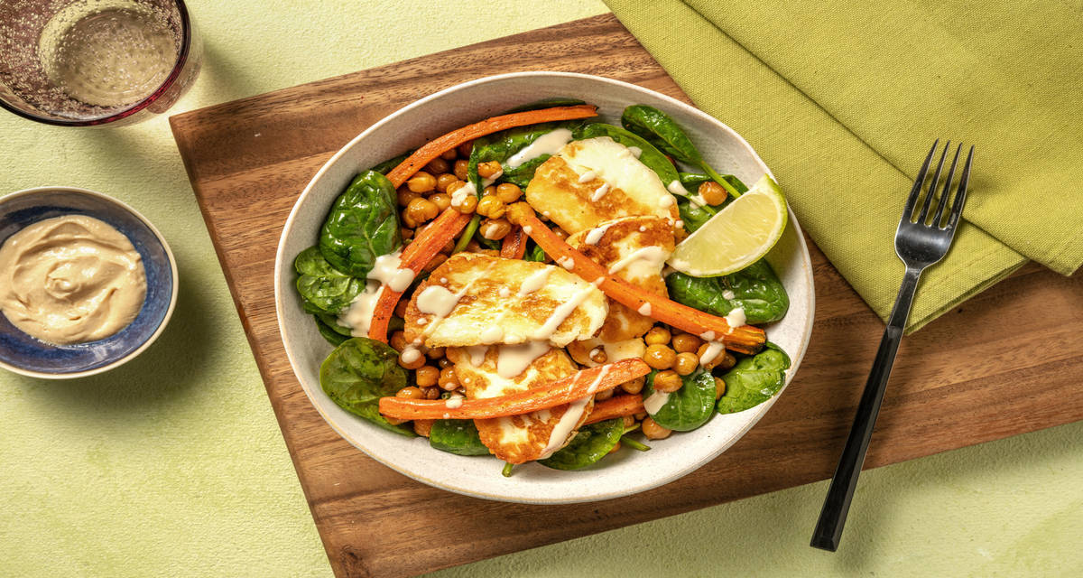 Queso estilo chipriota en salsa de cacahuete y lima sobre ensalada de espinacas, garbanzos y zanahoria asada