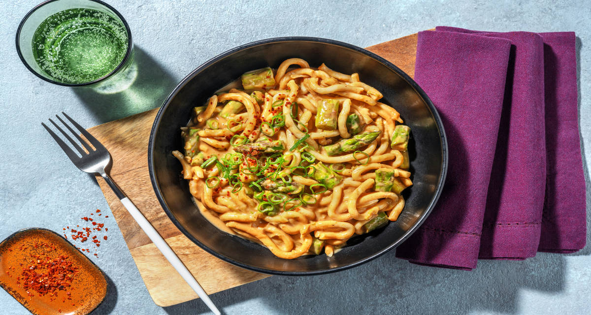 Fideos udon con salsa de cacahuete con espárragos salteados, ajo tierno y chili