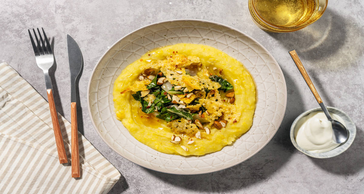 Crema soffice di patate e mais e cialde al formaggio con bietole piccanti e granella di mandorle