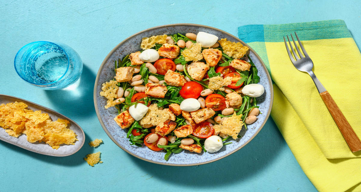 Ensalada de salmón con queso en dos texturas con rúcula, tomates cherry y judías blancas