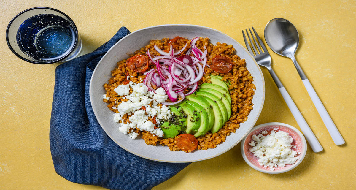 Bulgur al formaggio greco e avocado con pomodorini e cipolla cruda marinata