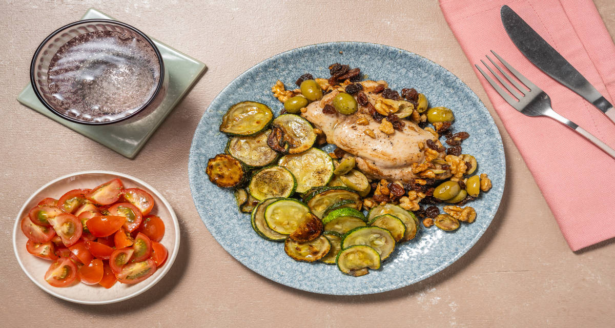 Pollo alle olive, noci e uvetta con zucchine trifolate e pomodorini