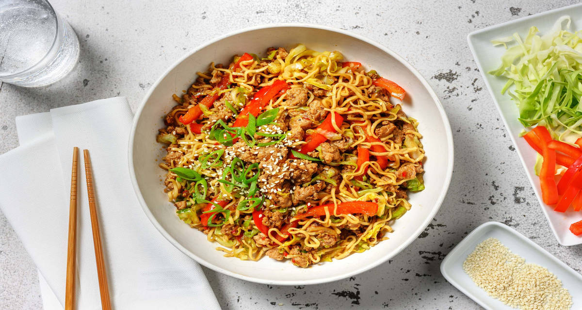Bulgogi stir-fry met noedels en varkensboerenworst met spitskool, sesamzaad en lente-ui