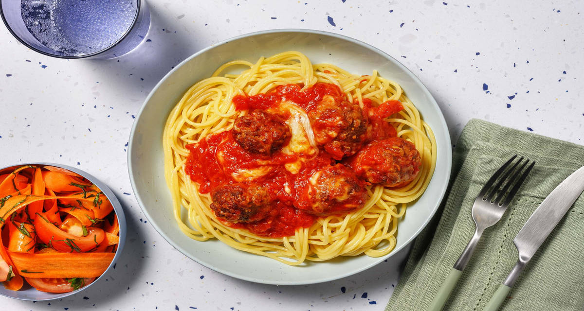 Bagte kødboller i ostesauce og spaghetti med gulerodssalat med tomat og basilikum