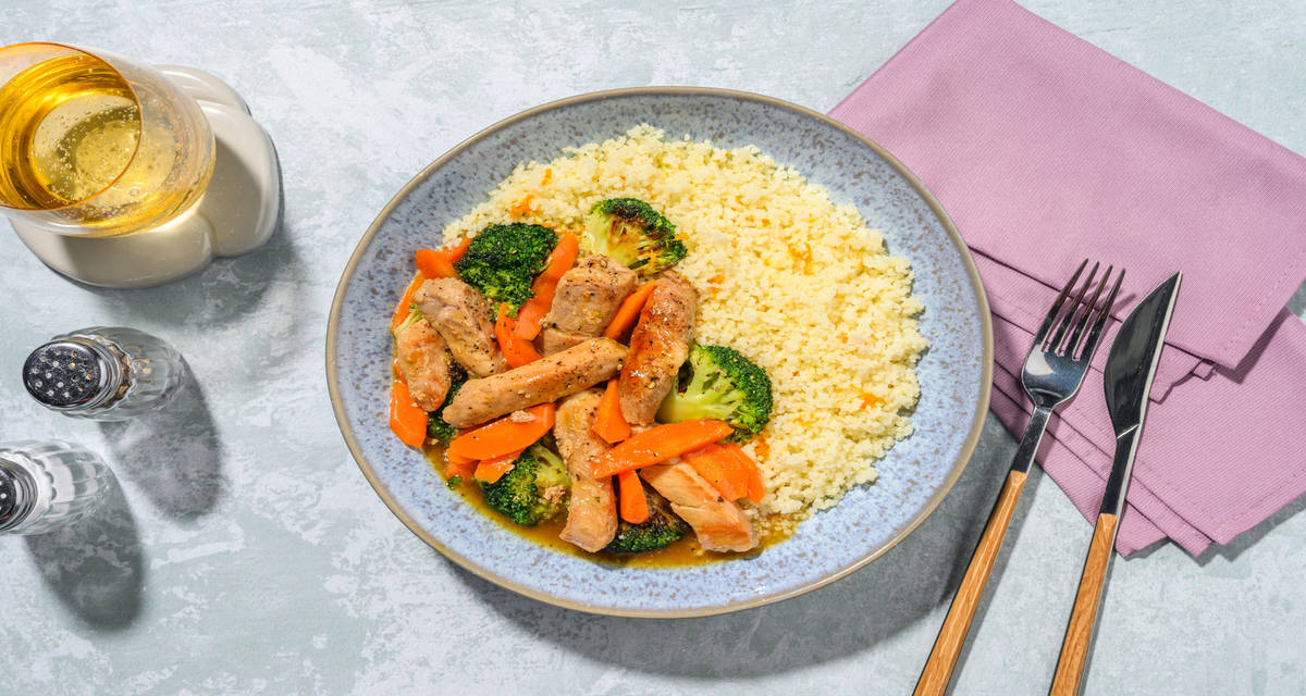 Tiras de cerdo en salsa casera de naranja con verduras servido sobre cuscús