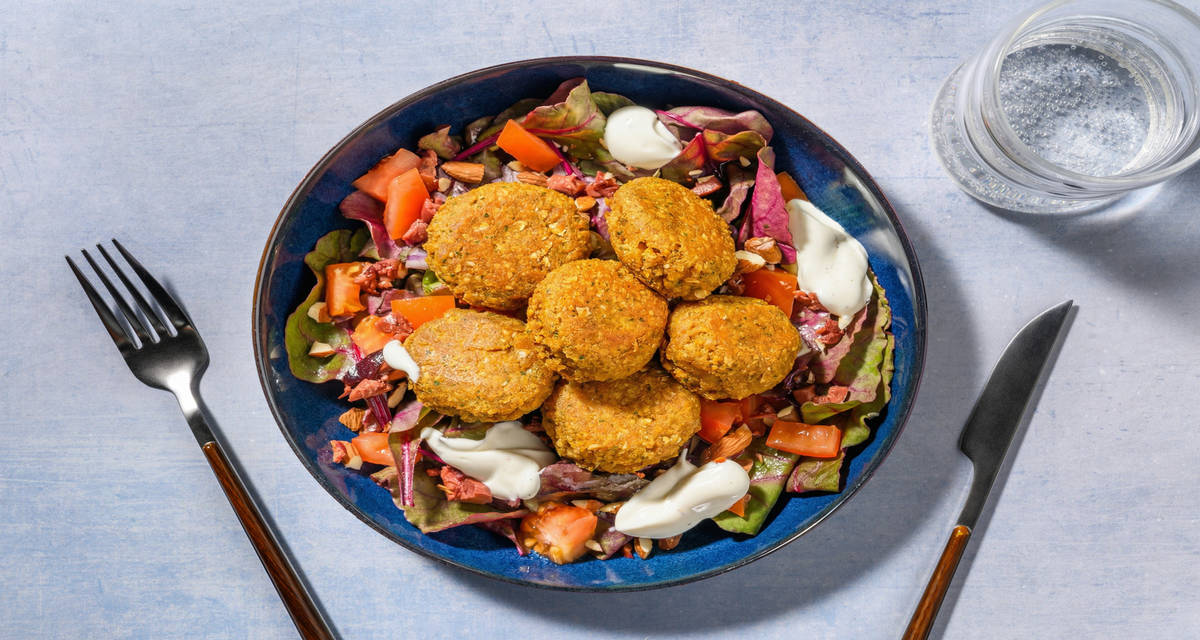 Falafel fritti e crema yogurt al cumino con insalata rossa, pomodoro e olive