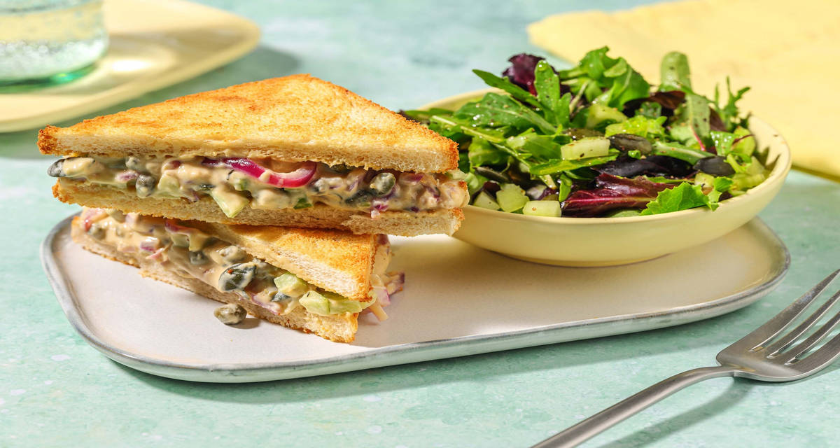Sandwich alla crema di ceci e cipolle con senape, insalata e semi di zucca