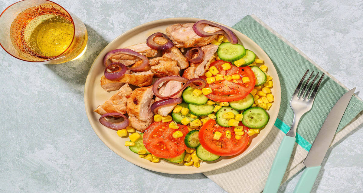 Bistecche di cosce di pollo e cipolle dolci con cetriolo, pomodoro e mais