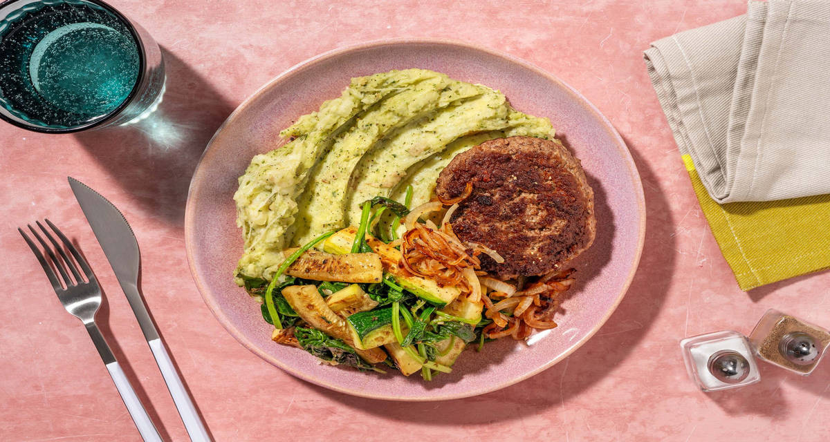Hamburger met cheesy pesto-aardappelpuree met basilicum met courgette, oregano, gebakken ui en spinazie