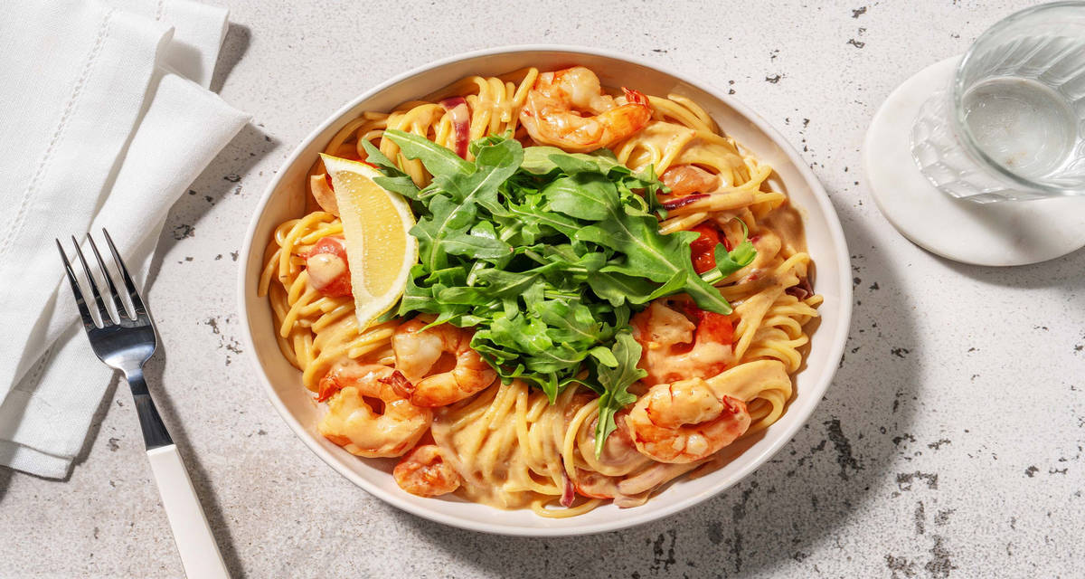 Snelle spaghetti met citroen-knoflookgarnalen met romige tomatensaus en rucola