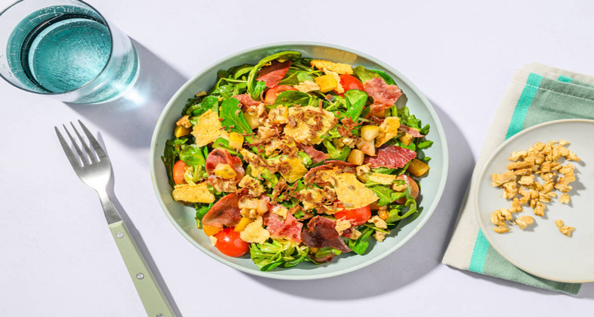 Crunchy salad: ensalada con crujiente de jamón y de queso con pera, cebolla frita y vinagreta de mostaza y soja