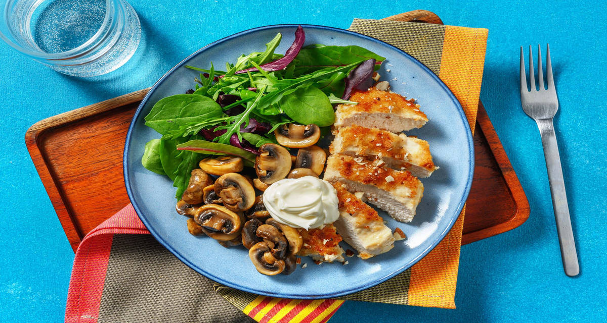 Cotolette dorate di pollo e funghi trifolati con insalata e granella di mandorle