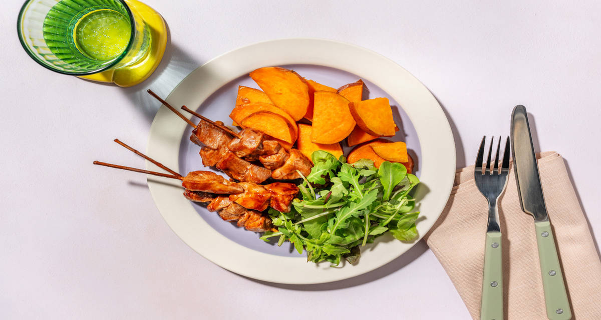 Arrosticini di suino in glassa barbecue con patate dolci, worcester e insalata
